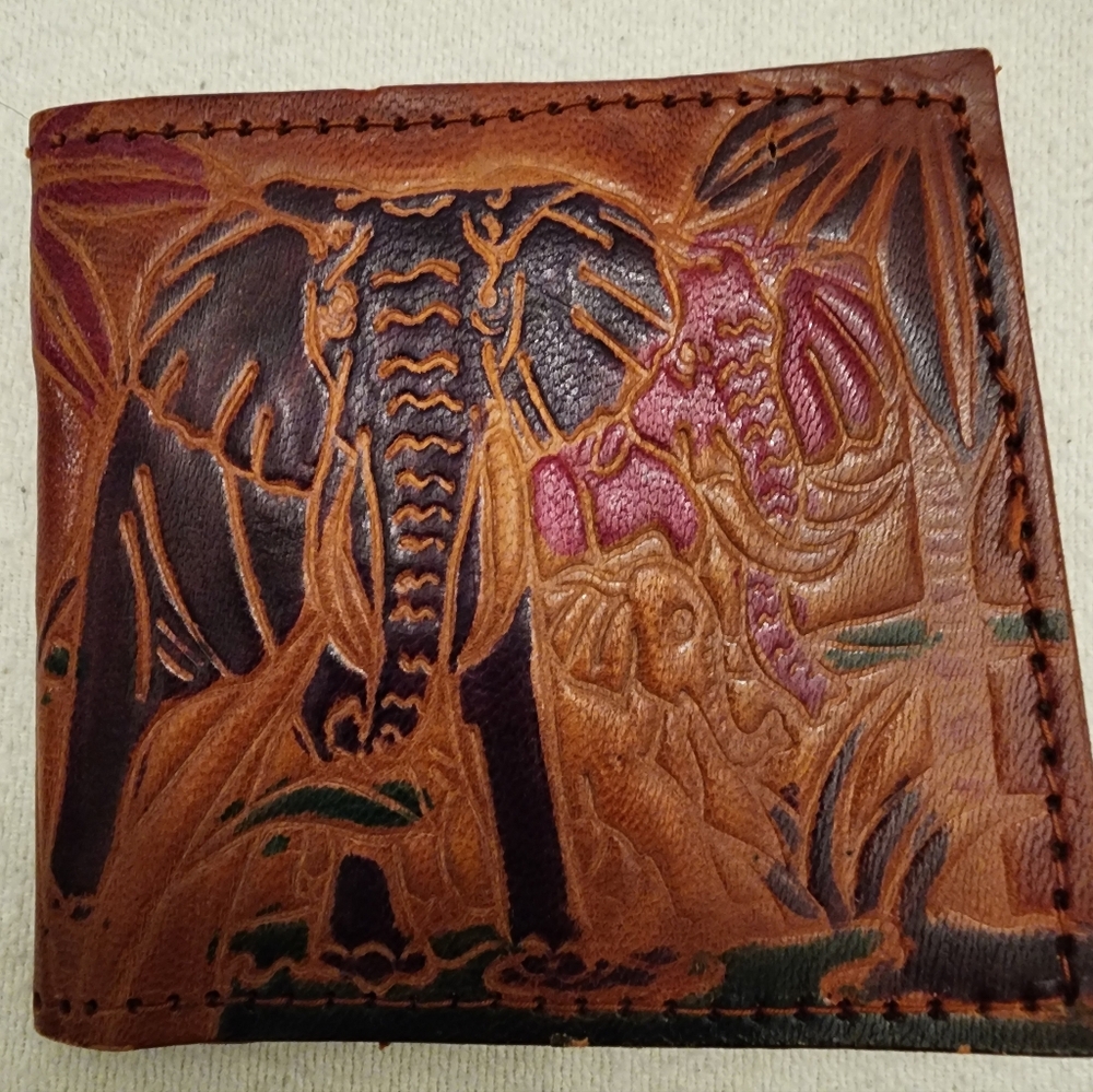 Vintage hand-tooled leather bifold wallet featuring an elephant safari design